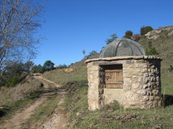 Pou de Bartolina i l'església de Sant Cristòfol al fons