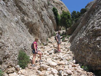 La Sílvia i el Toni pujant per una tartera a les Roques d'en Benet